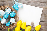 Easter greeting card with blue and white eggs and yellow tulips 