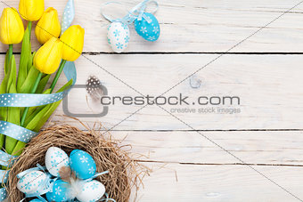 Easter background with blue and white eggs in nest and yellow tu