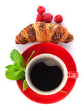 Cup of coffee, fresh croissant and berries