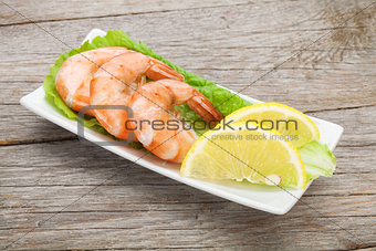 Cooked shrimps with lemon and salad leaves