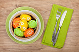 Easter eggs nest on plate over wooden background