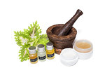 Wooden pounder with bottles of organic oils and cream isolated