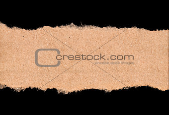 piece of torn kraft paper on a black background