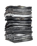 high stack of jeans gray and black on a white background