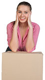 Woman resting her elbows on cardboard box