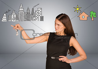 Woman making choice between city and country, looking at keys in her hand
