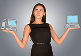 Woman making choice between desktop computer and laptop
