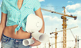 Woman holding hard hat and drawing rolls 