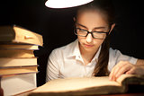 Young girl reading book under lamp