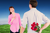 Composite image of man holding roses behind him