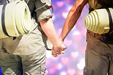 Composite image of hitch hiking couple standing holding hands on the road