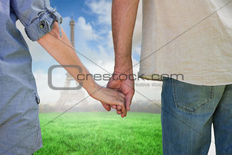 Composite image of couple holding hands in park