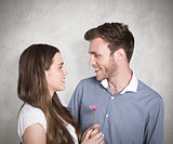 Composite image of man kissing woman as she holds flower
