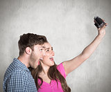 Composite image of couple taking selfie with digital camera