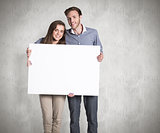 Composite image of full length portrait of couple with blank board