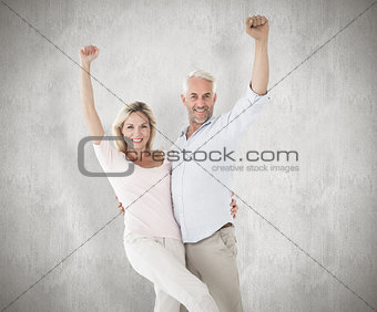Composite image of smiling couple cheering at the camera