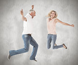 Composite image of excited couple cheering and jumping