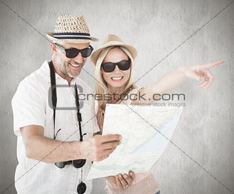 Composite image of happy tourist couple using map and pointing