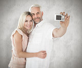 Composite image of happy couple posing for a selfie