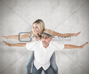 Composite image of happy man giving his partner a piggy back