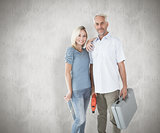 Composite image of happy couple holding diy tools