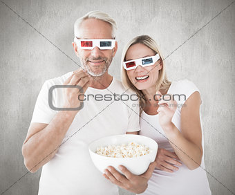 Composite image of happy couple wearing 3d glasses eating popcorn