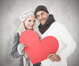 Composite image of smiling couple in winter fashion posing with heart shape