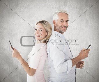 Composite image of happy couple texting on their smartphones
