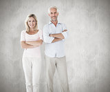 Composite image of smiling couple standing with arms crossed