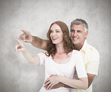 Composite image of casual couple smiling and pointing