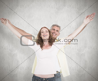 Composite image of casual couple smiling with arms raised
