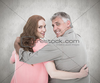 Composite image of casual couple standing arms around