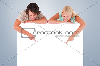 Composite image of man and woman pointing on a whiteboard