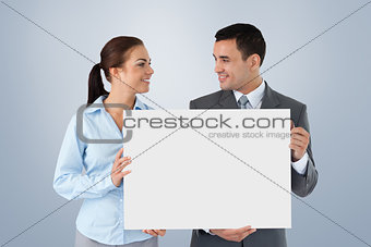 Composite image of young business partners presenting sign