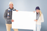 Composite image of attractive couple in winter fashion showing poster