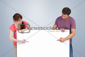 Composite image of couple looking at a sign
