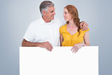 Composite image of casual couple showing a poster