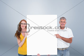 Composite image of casual couple showing a poster