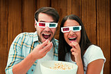 Composite image of attractive young couple watching a 3d movie