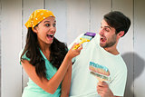 Composite image of happy young couple painting together and laughing