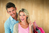 Composite image of attractive young couple holding shopping bags