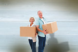 Composite image of older couple smiling at camera holding moving boxes