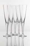 Five champagne glasses on a glass desk