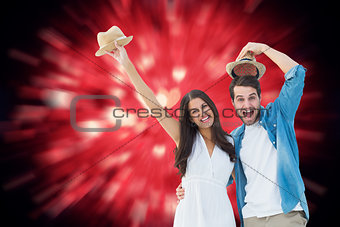 Composite image of happy hipster couple smiling at camera and cheering