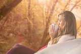 Composite image of pretty blonde relaxing on the couch with tea