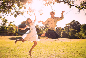 Cute couple jumping in the park together