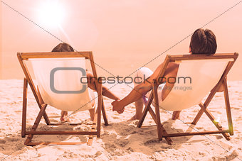 Couple lying on deck chairs