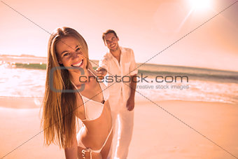 Woman smiling at camera with boyfriend holding her hand