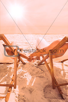 Cute couple lying on deck chairs