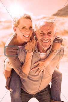 Laughing couple smiling at camera on the beach